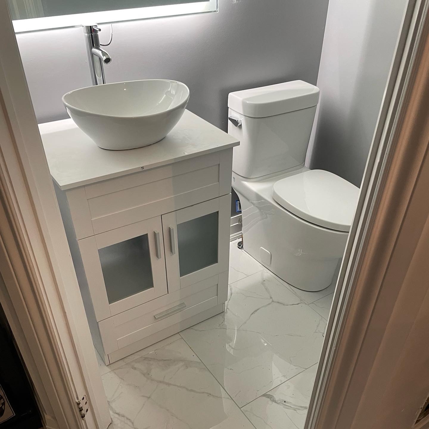 Completed basement bathroom with vessel sink vanity and toilet installed by HSC Plumbing